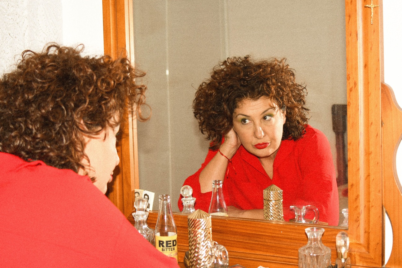 Isabel (Ayalén) looking at herself in the mirror.