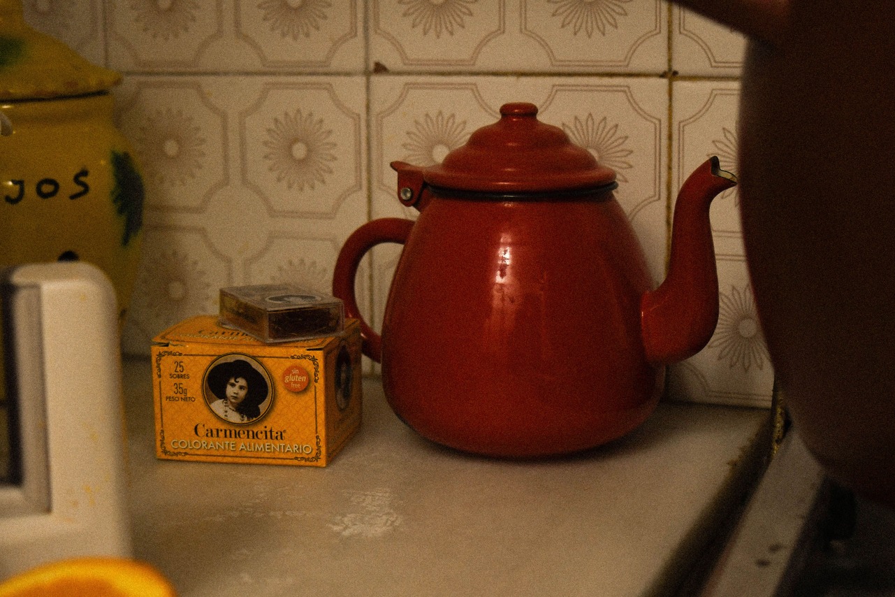 Carmencita colorant beside a red kettle.