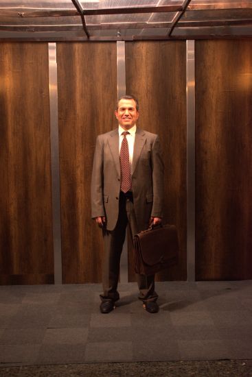 Carles amb les mans relaxades als costats i el maletí a la mà esquerra